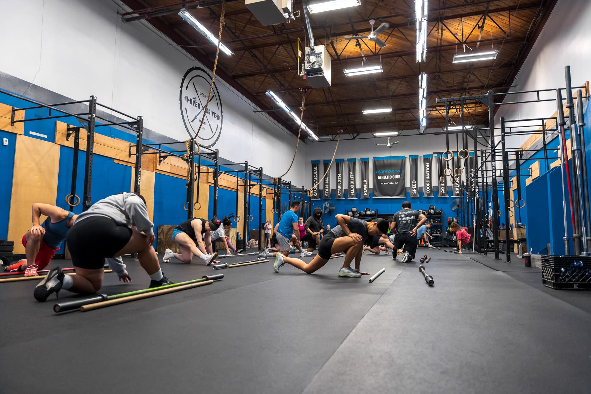 A CrossFit class warming up with barbells on mats at Overdrive Athletic Club in Richmond, BC