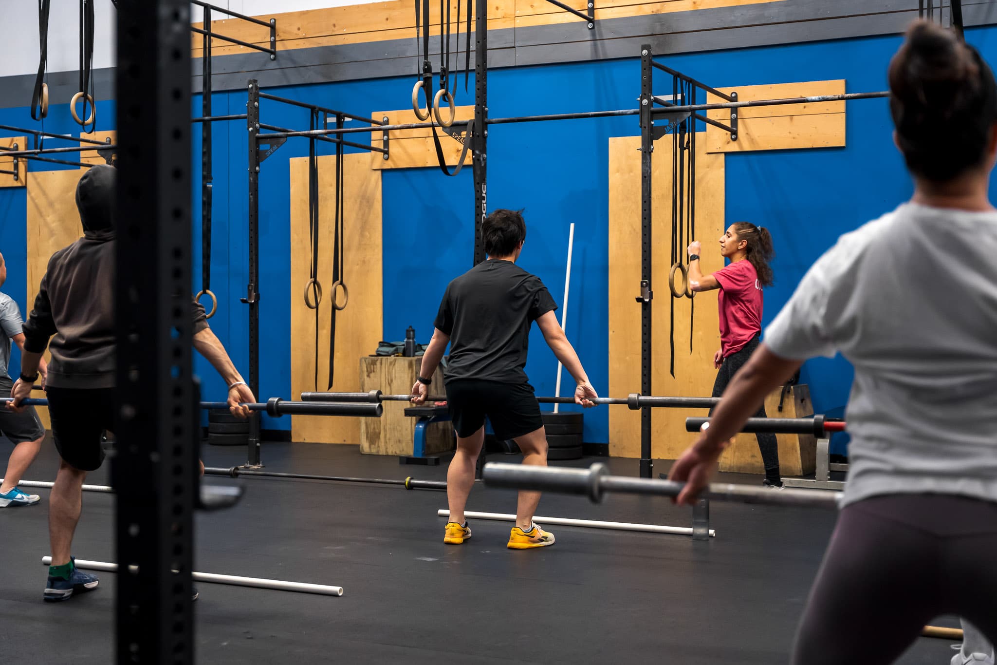 Gym members standing at their barbells before a workout at Overdrive Athletic Club in Richmond, BC
