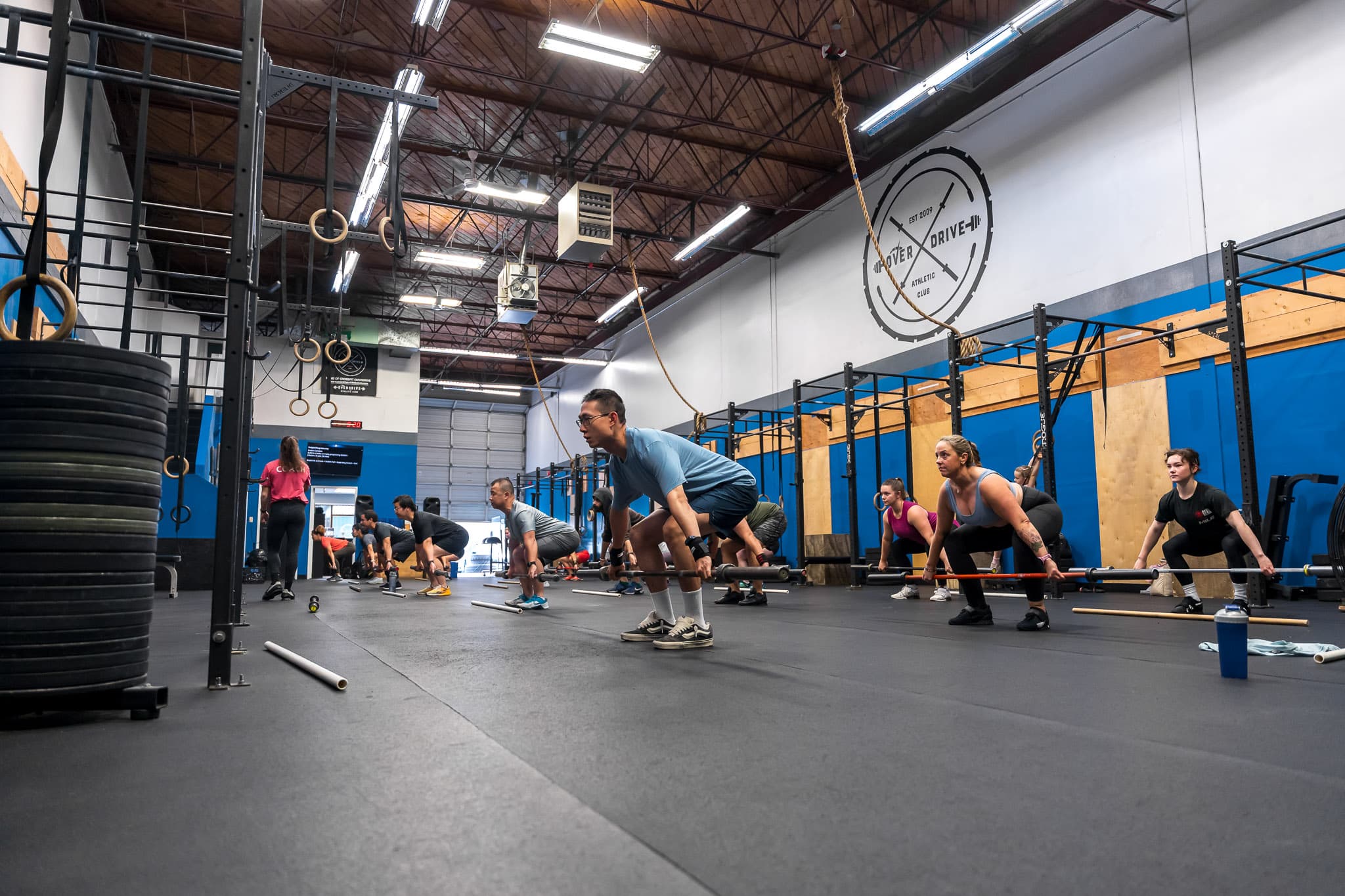 Members performing barbell deadlifts in a group CrossFit class at Overdrive Athletic Club in Richmond, BC