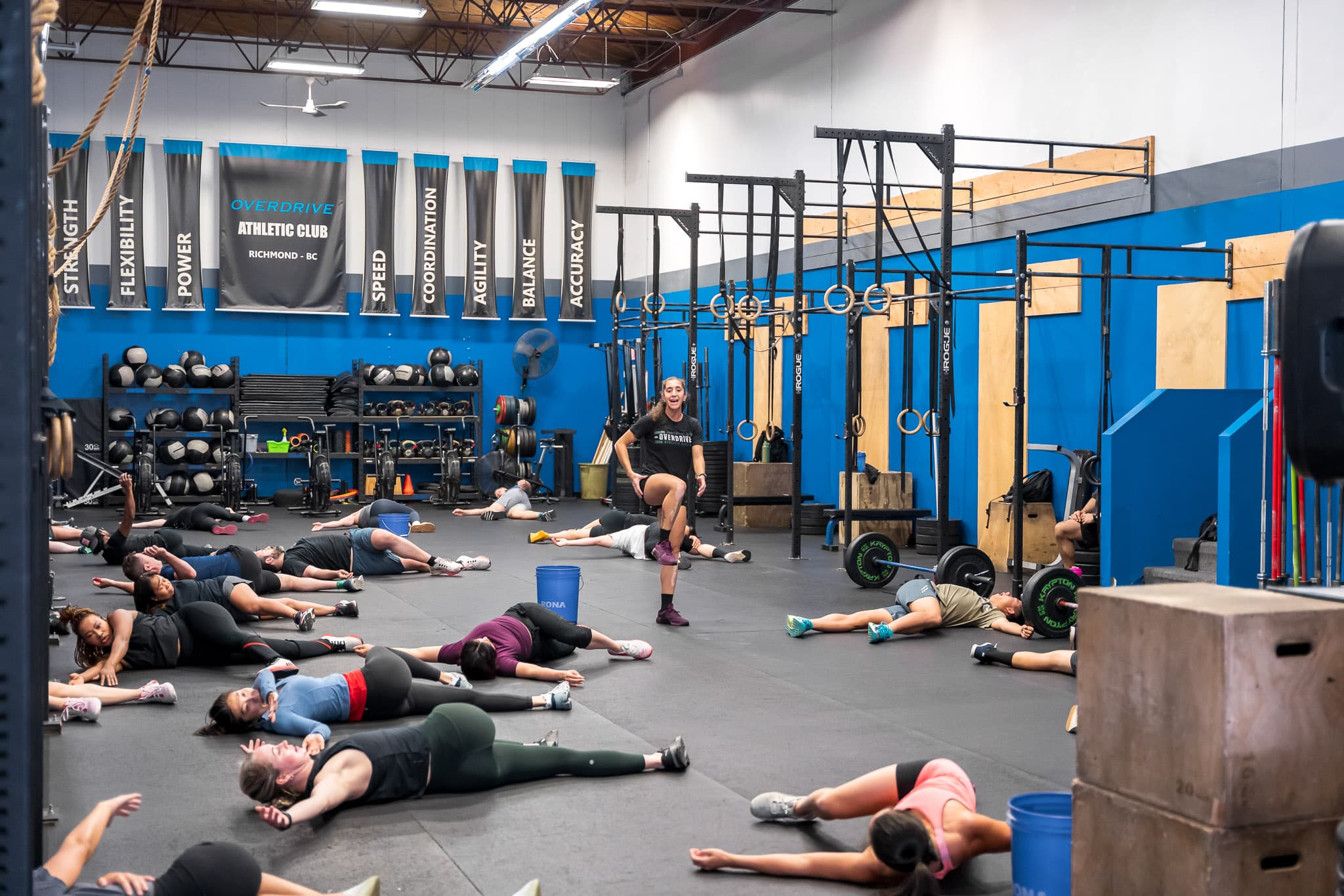 A coach demonstrating a standing stretch to a class at Overdrive Athletic Club in Richmond, BC