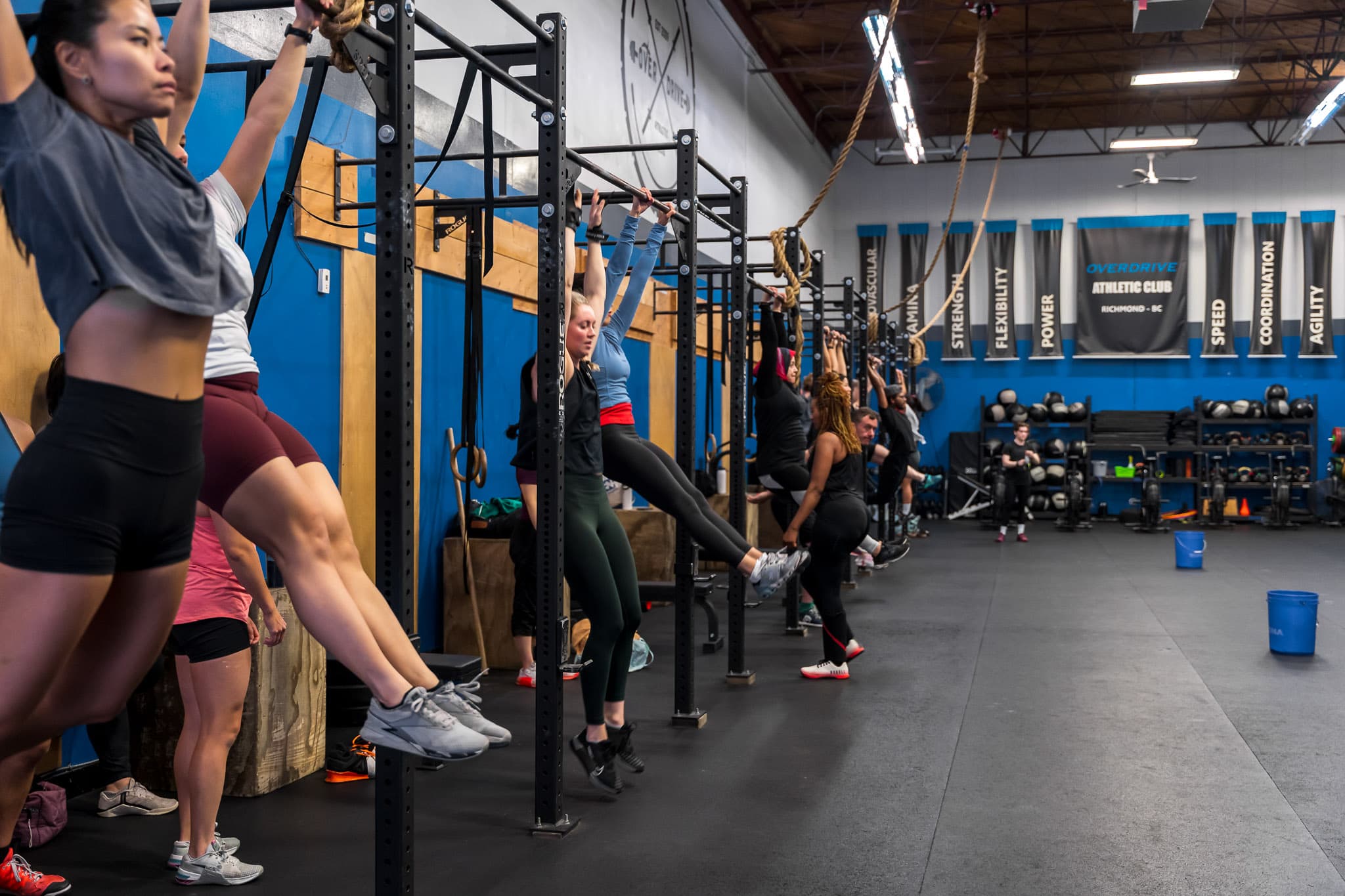 Members performing toes-to-bar on the rig during a class at Overdrive Athletic Club in Richmond, BC